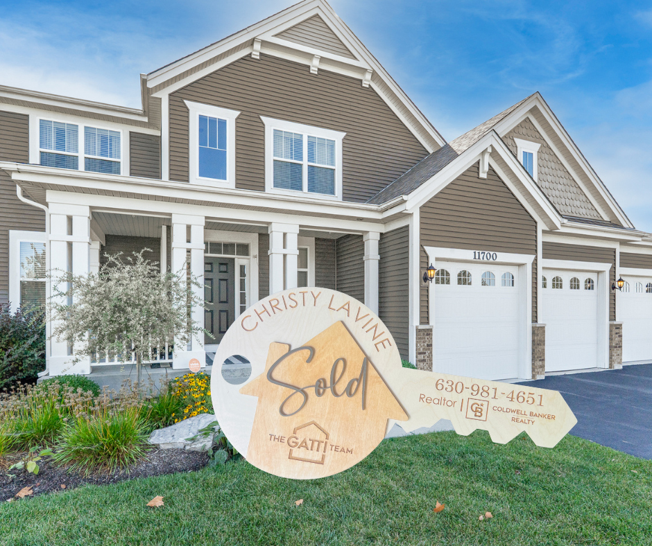 A beautiful home with a wooden key stating SOLD and my contact information