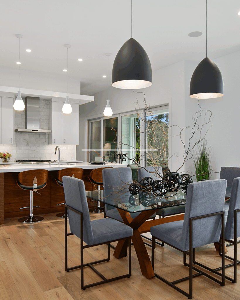 kitchen in dining area with canned lights, pendant lights over the island and dome lights over the table.